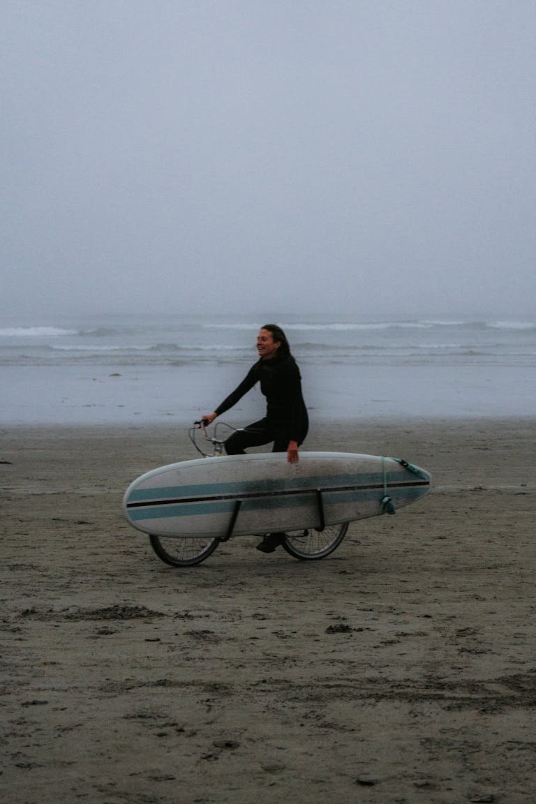 Woman Riding E-Bike with Surfboard on Rack